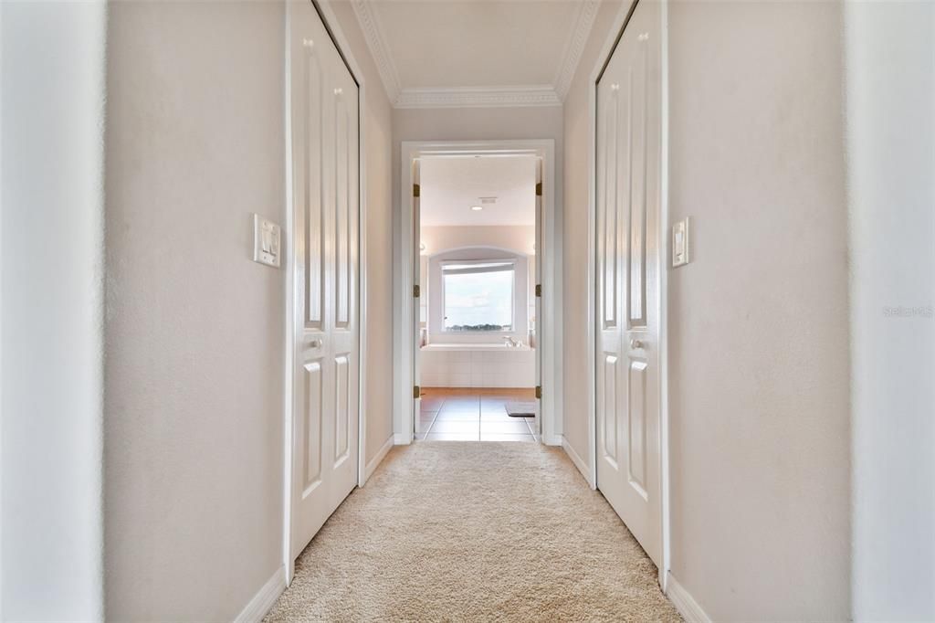 Master en-suite hallway from bedroom to his and hers walk in closets