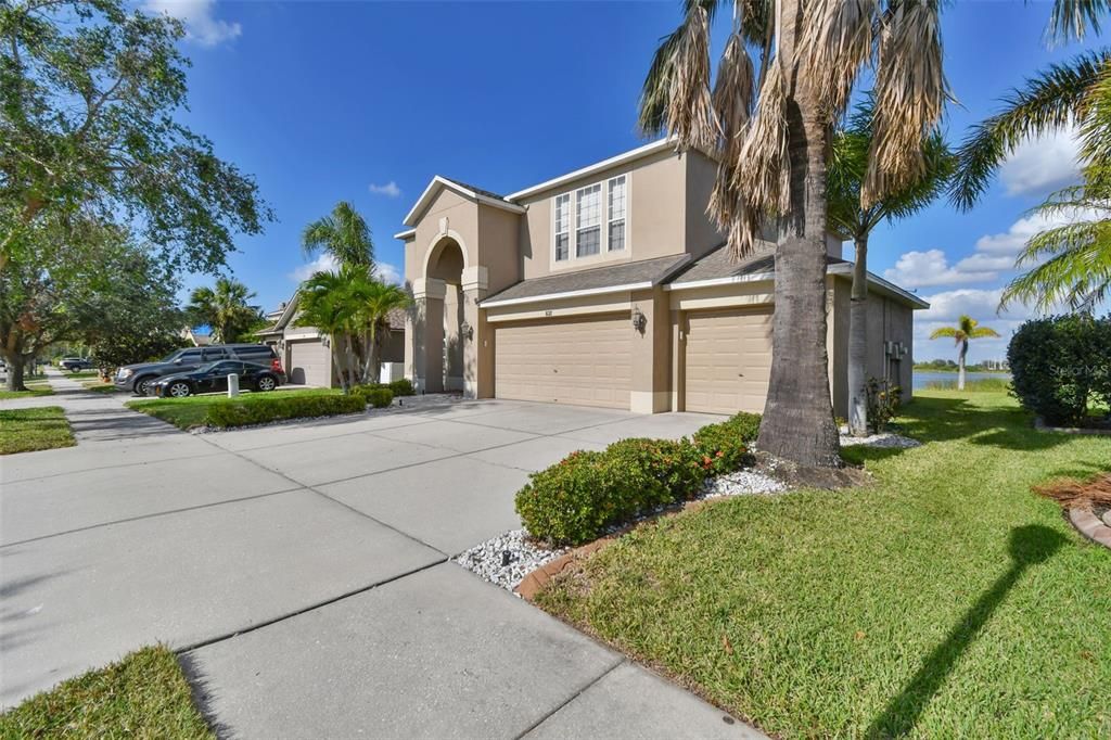 Side view . Large driveway leads to 3 car garage