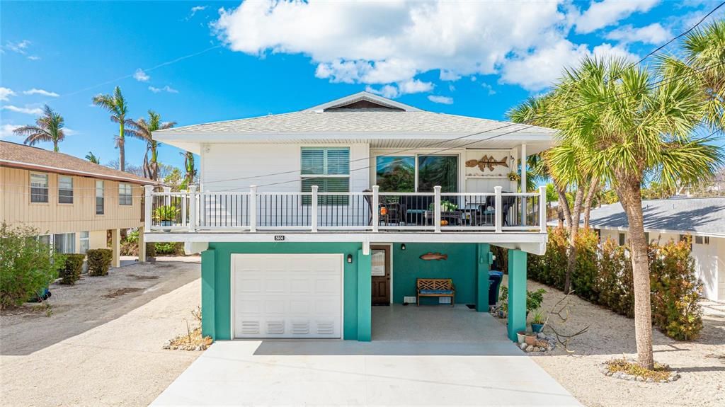 Elevated home with a single car garage and carport.