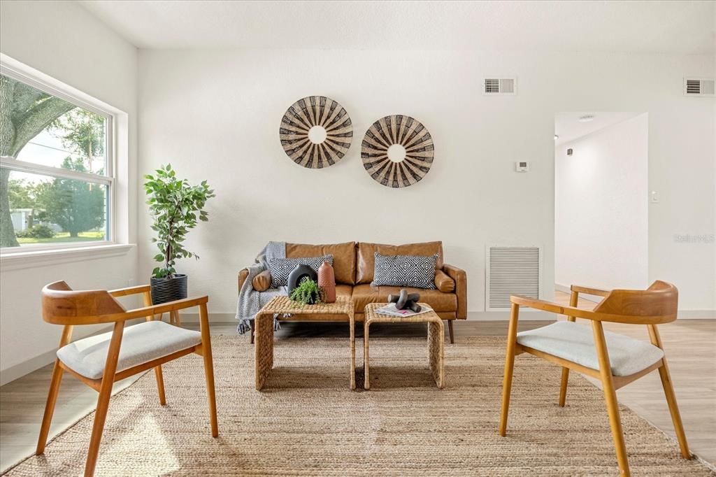 Tasteful and open this room flows right into the kitchen, family room and then out to the pool