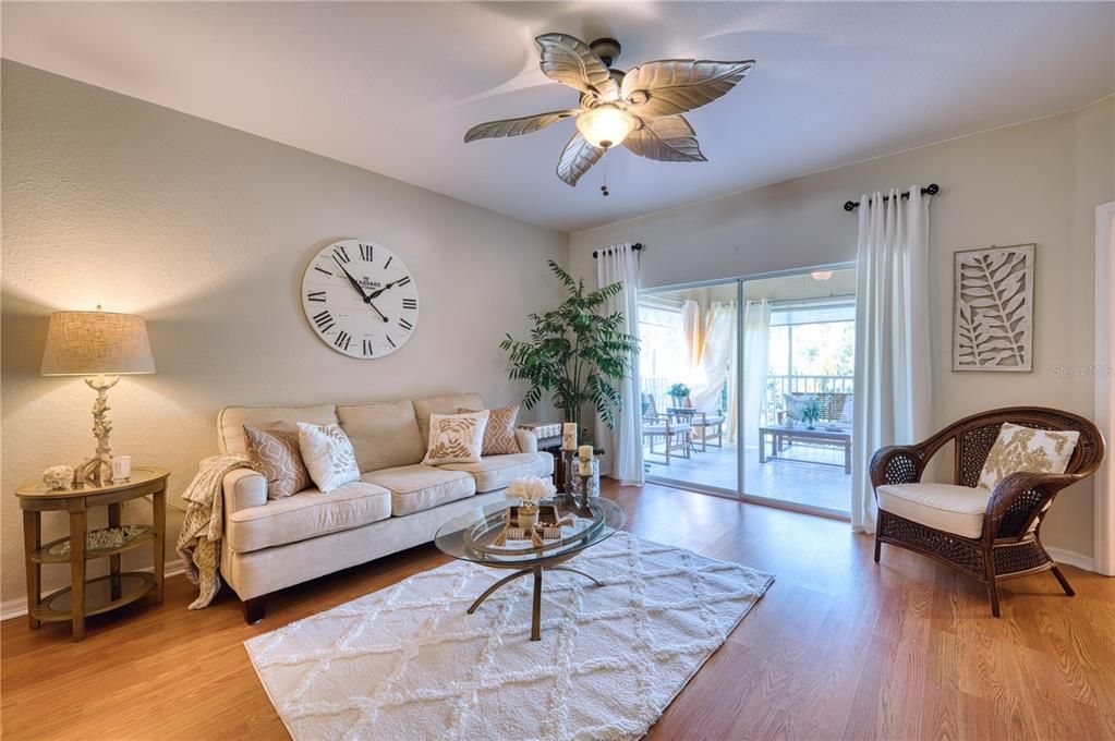 Living Room with Slider Doors out to the screened in patio with rare pool view.