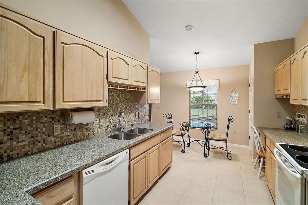 Kitchen has expansive counter space, tile flooring, built in desk and dining space.