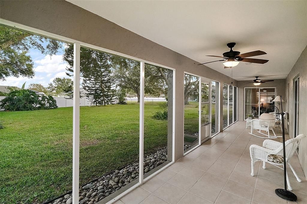 Tile lanai, screened with ceiling fans; overlooks the expansive fenced backyard.