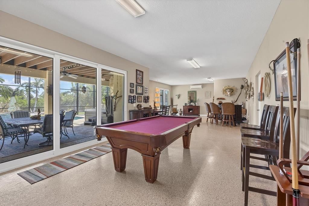 Other end of the Game Room with a half Bath. Sliders to Pool area