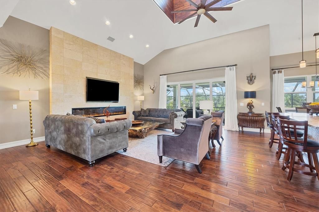 Livingroom -Sliders to pool Deck-Kitchen Breakfast Bar-African Acacia Wooden Floor Throughout-Cupola Ceiling