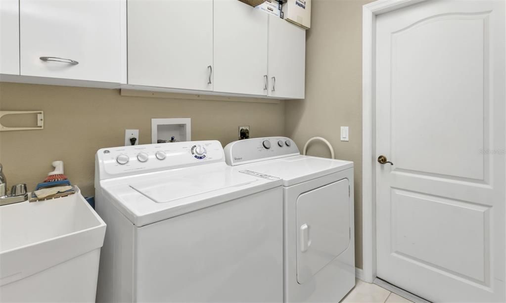 INTERIOR LAUNDRY ROOM WITH UTILITY SINK AND STORAGE CABINETS