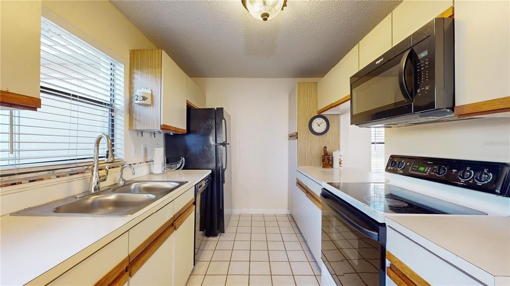 Upon entering the kitchen, you'll find a cozy, well-equipped space with classic cabinetry, durable countertops, and plenty of storage, offering a practical and welcoming environment for cooking and gathering.