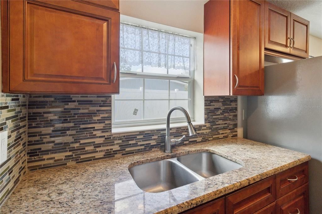 Kitchen sink with window overlooking pool and backyard