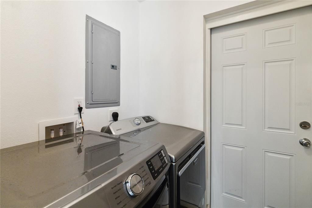 Laundry Room with door leading out to backyard and pool area.