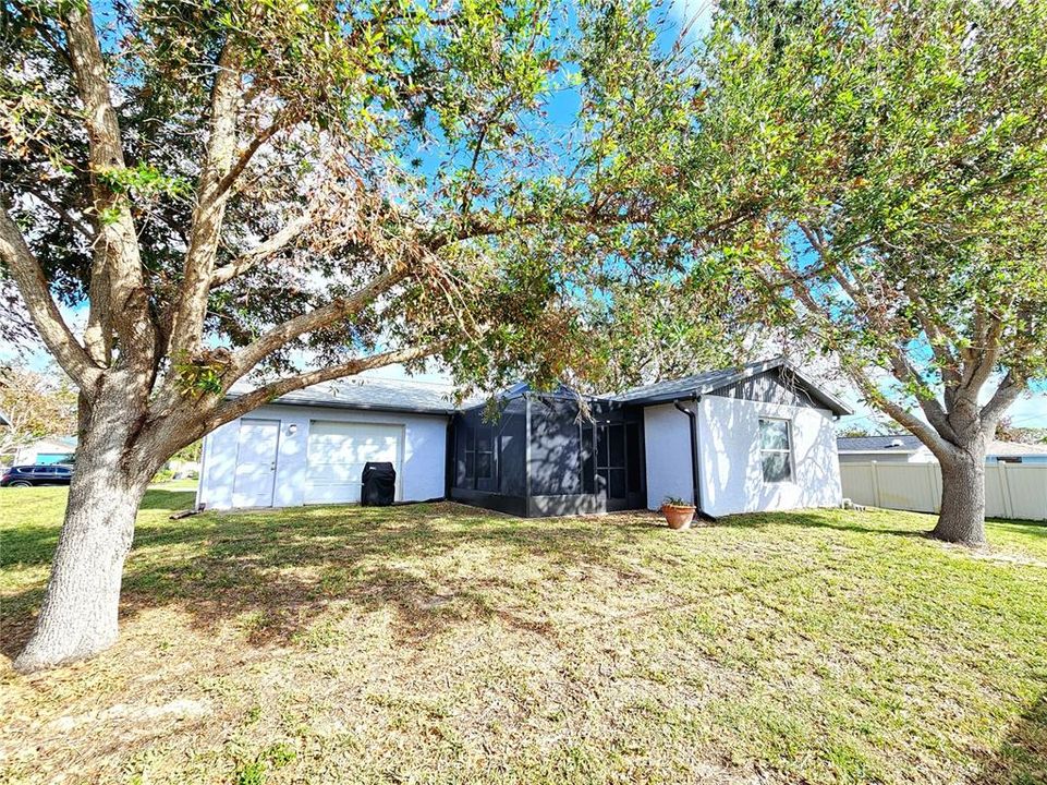 Back exterior with large oak trees