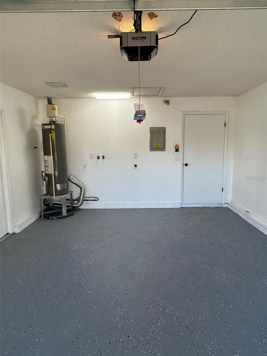 Garage with gas water heater and laundry area