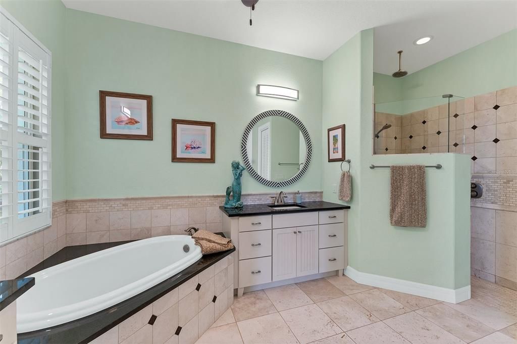 Walk-in shower with multiple shower heads and a bench.