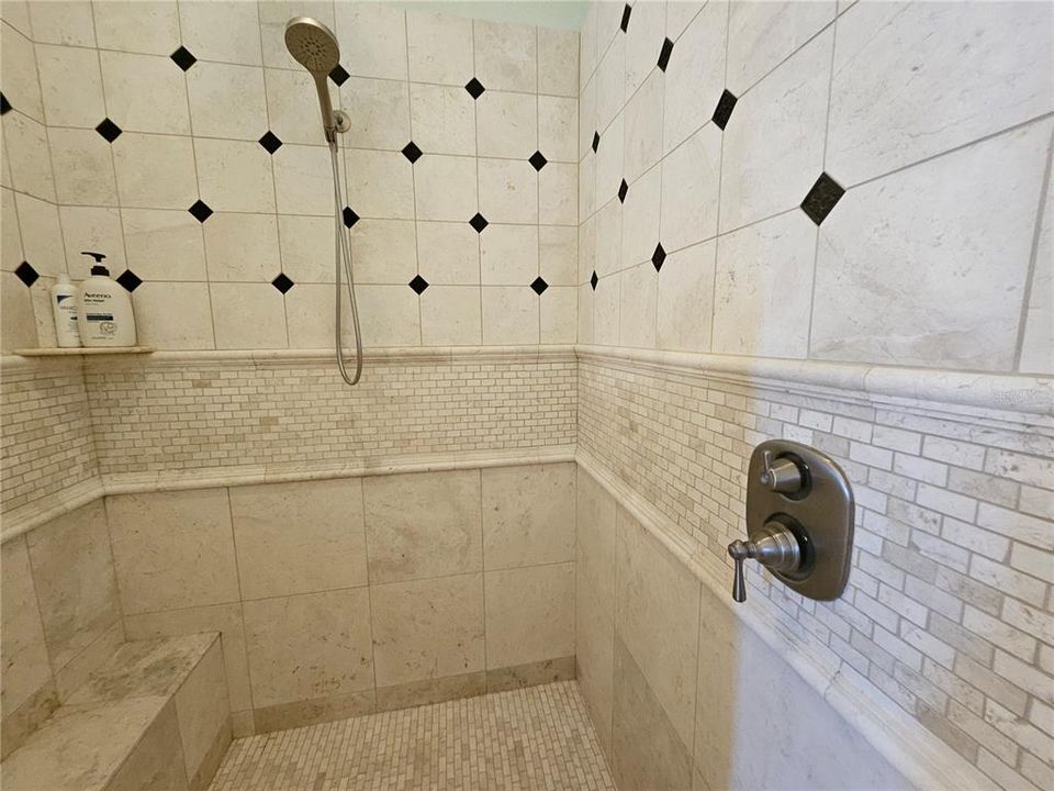 Pretty tile work and bench in owner's shower.