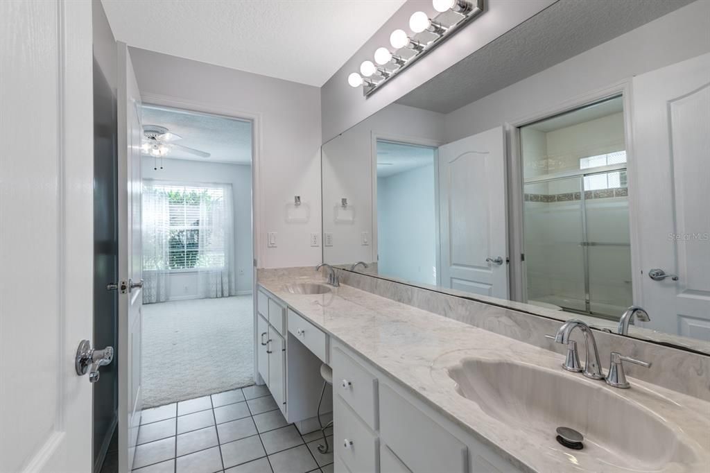 Guest bathroom with double vanity sinks and private bath an toilet area