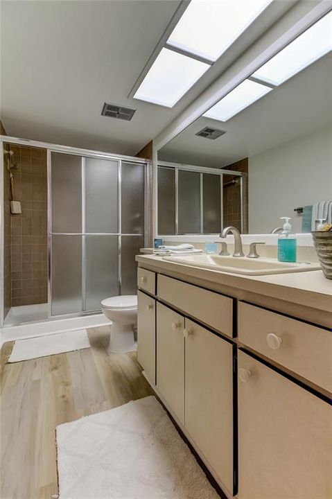 Owner's Retreat Bathroom.. offers extra counter space, walk in shower w/ sliding glass doors, Brand New Faucet & Luxury Vinyl Flooring just installed!