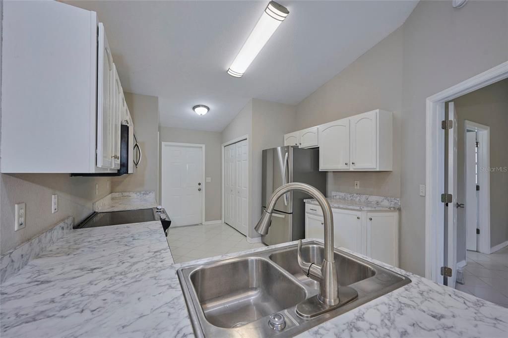 Kitchen is galley style and has lots of cabinetry and counter space.