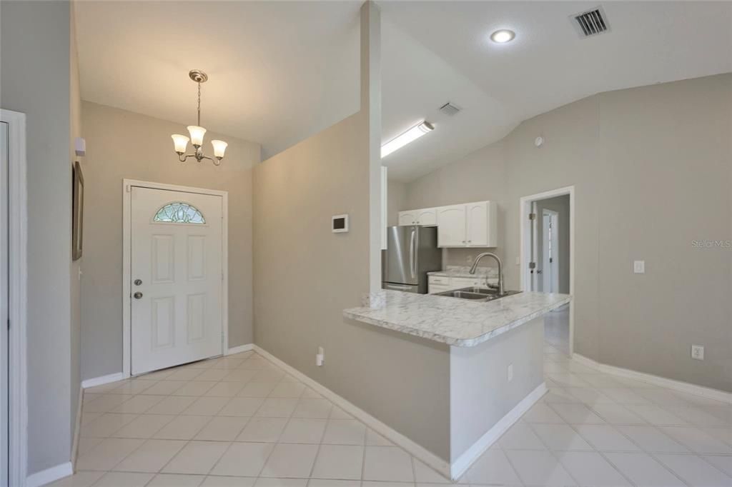 Foyer entrance with view of kitchen