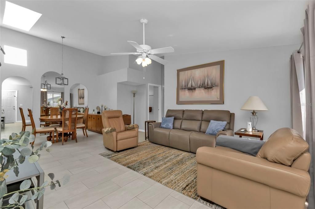 LIVING ROOM OPEN TO DINING ROOM, PORCELAIN TILE FLOORS - VAULTED CEILINGS