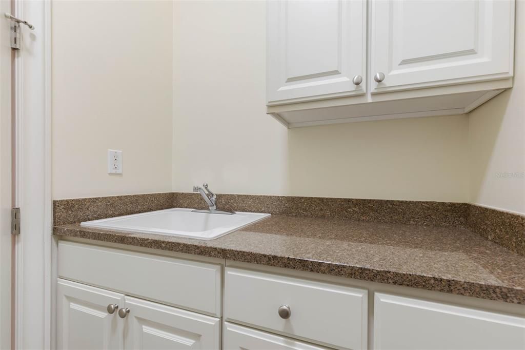 Sink, lots of cabinets & granite countertops in utility room