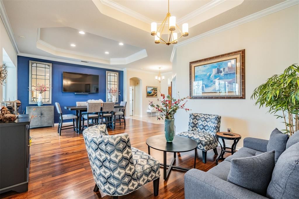 Living Room with Inset Ceiling, Crown Molding, Burma Walnut Flooring and Open to the Dining Room.