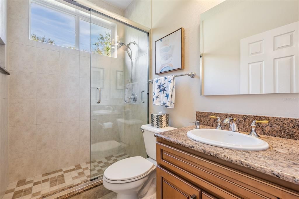 Guest Bathroom with Seamless Glass Door, New Vanity and Mirror.