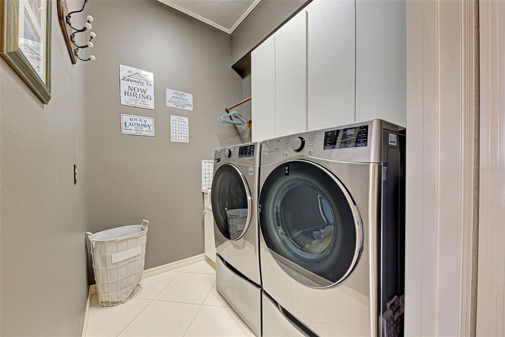 Interior laundry room with storage and tub.