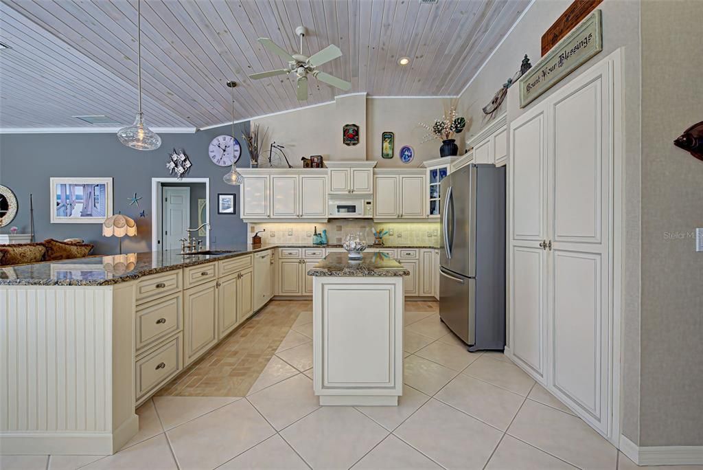 Gourmet kitchen has soaring ceilings with detailed woodwork, large island and pantry.