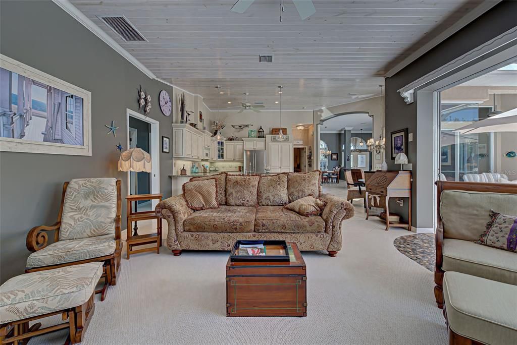 View of family room with kitchen and dining room in the distance.  Split floorplan offers 2 guest bedrooms and bath in the guest suite, to the left.