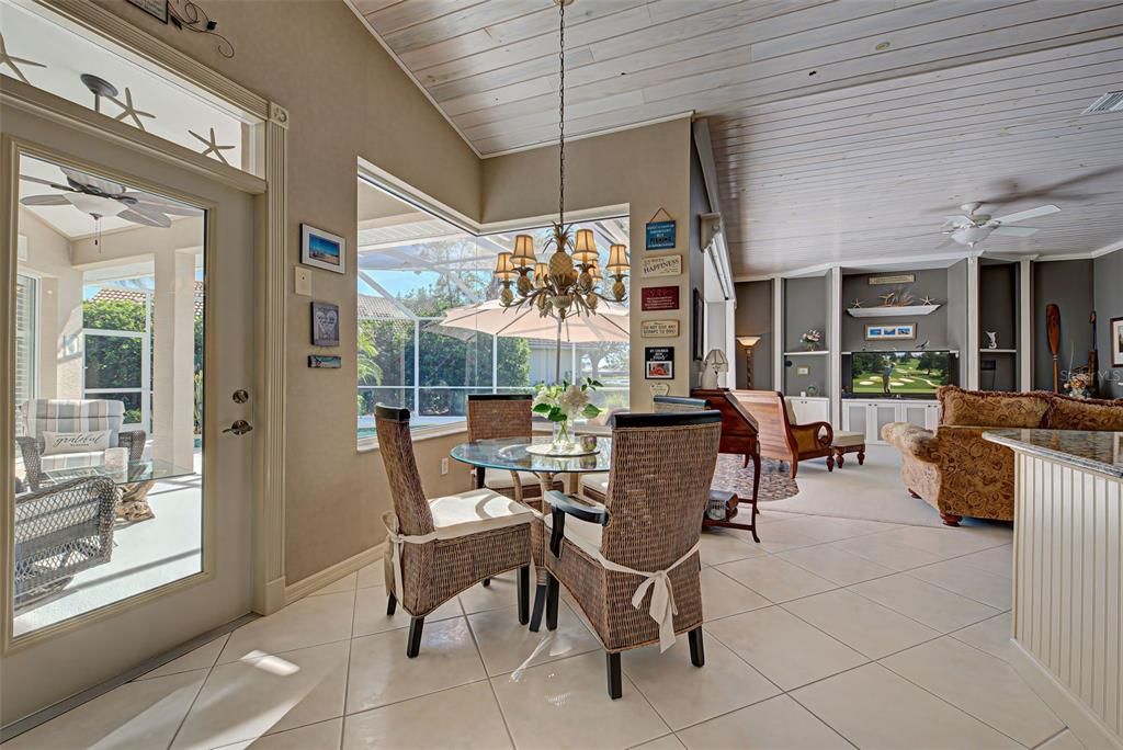 Cheerful breakfast nook has an aquarium window overlooking the pool and lanai.