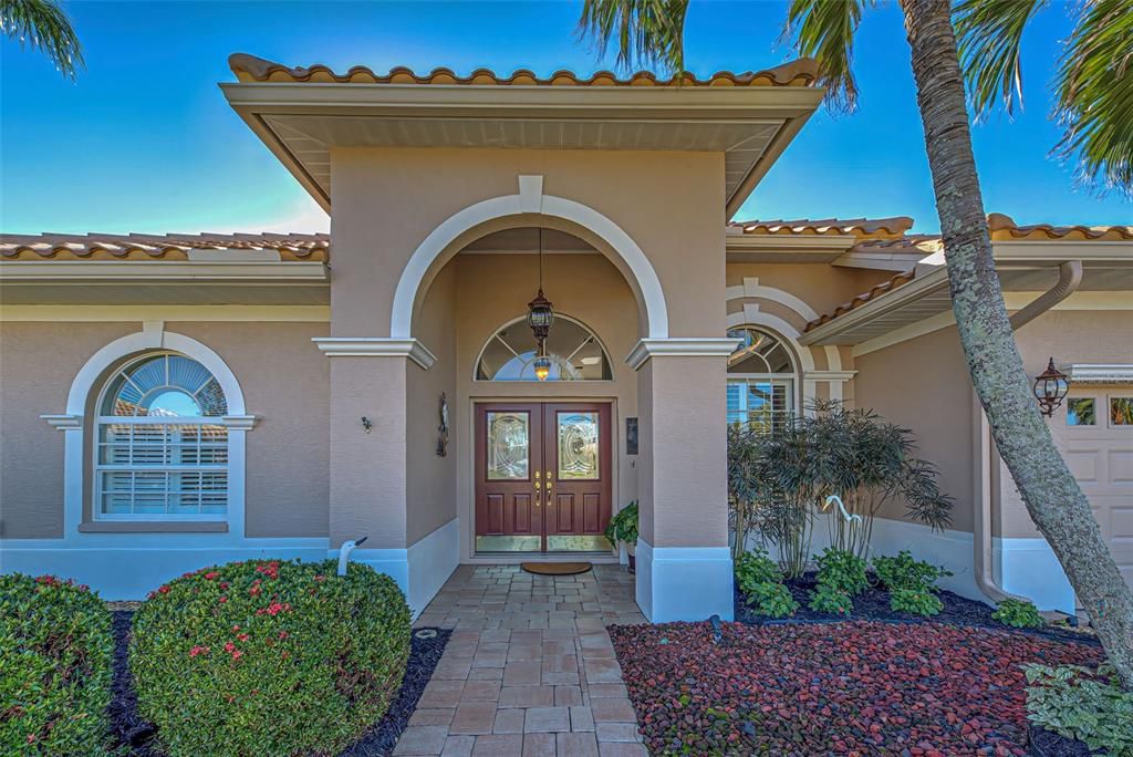 Custom built J & J home with welcoming double lead glass doors and paver pathway.