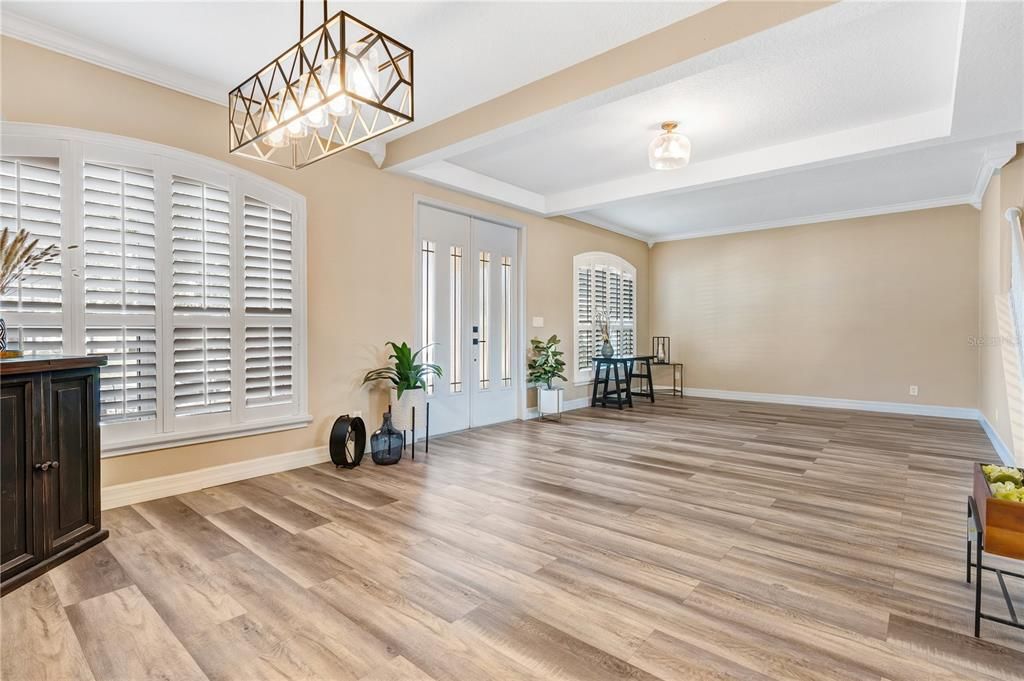 Spacious foyer with lots of natural sunlight flanked by a formal living room and a formal dining room.