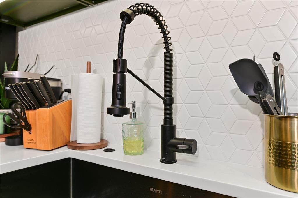 Matte black pull town faucet & a gorgeous geometric backsplash.