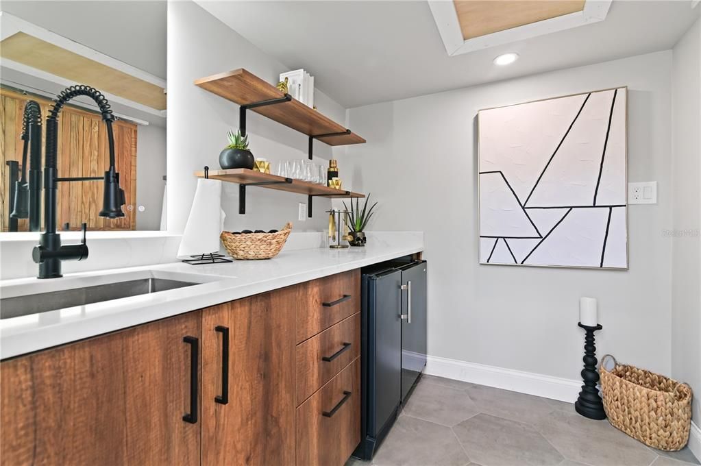 Mid-Century Modern Wet Bar features a 24" sink with pull out faucet, ice maker and mini fridge. Store your glassware or bottles on the shelves when entertaining outdoors and there is plenty of room in the drawers for other items you may need.