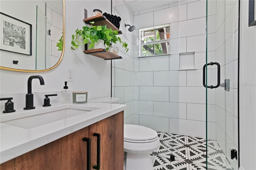 Mid-Century Modern guest bathroom features single vanity and walk in shower with glass enclosures