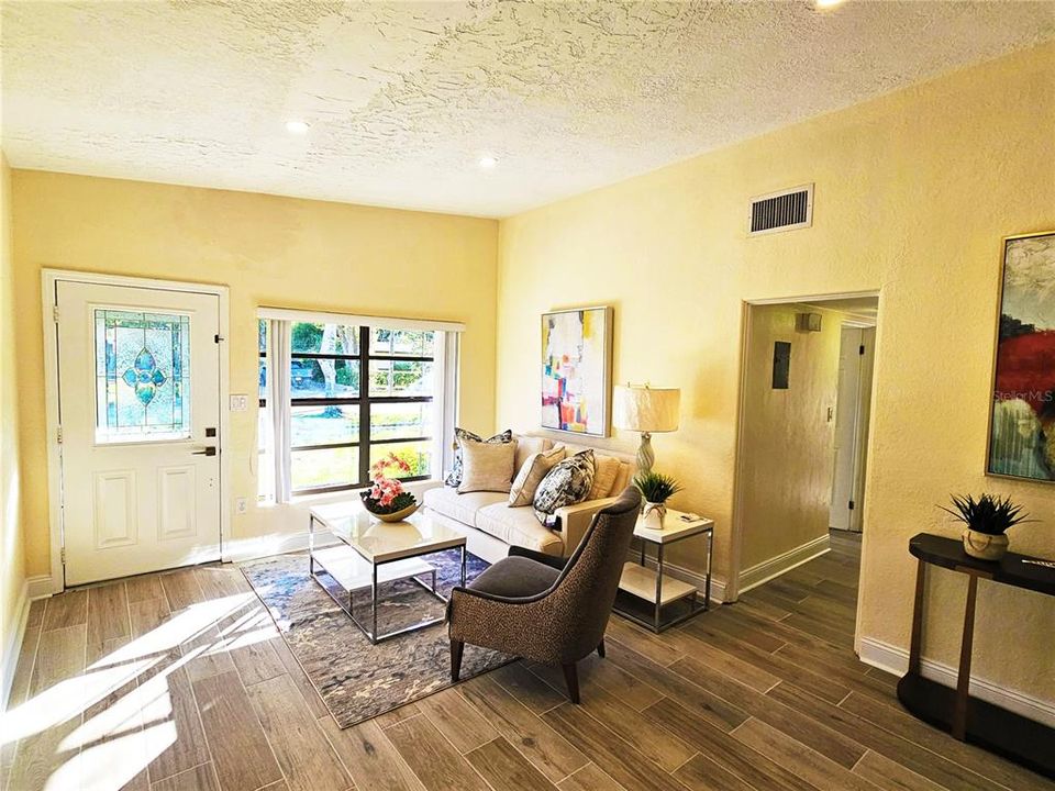 Living Room with a view of the front yard.  Staged photo. Present tenant's furnishings may differ