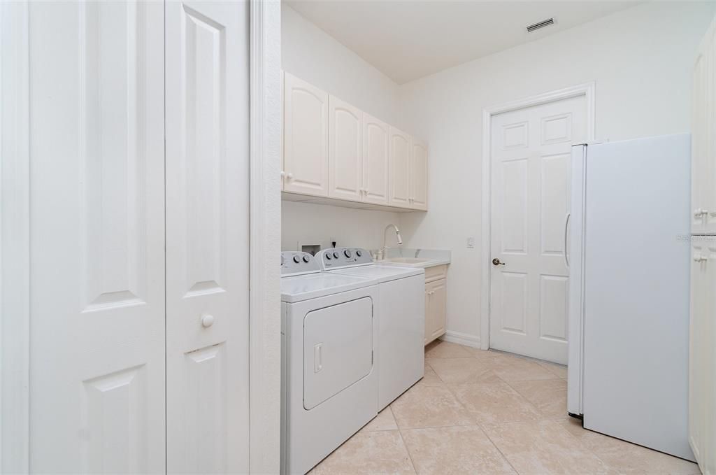 Laundry with pantry cabinets and refrigerator