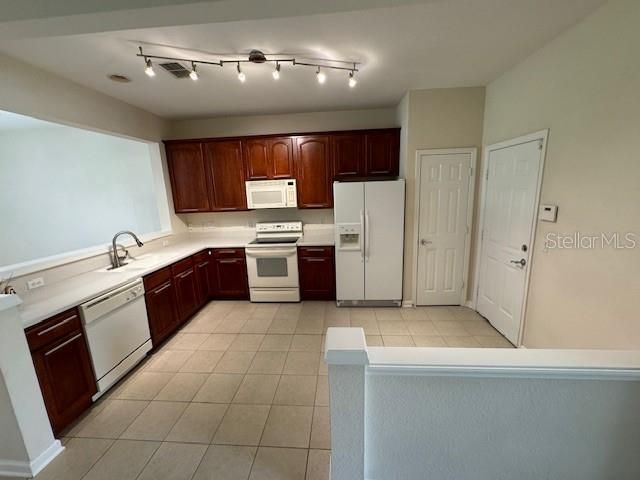 The open-concept kitchen is fully equipped with 42-inch cherry cabinets, offering ample storage space.