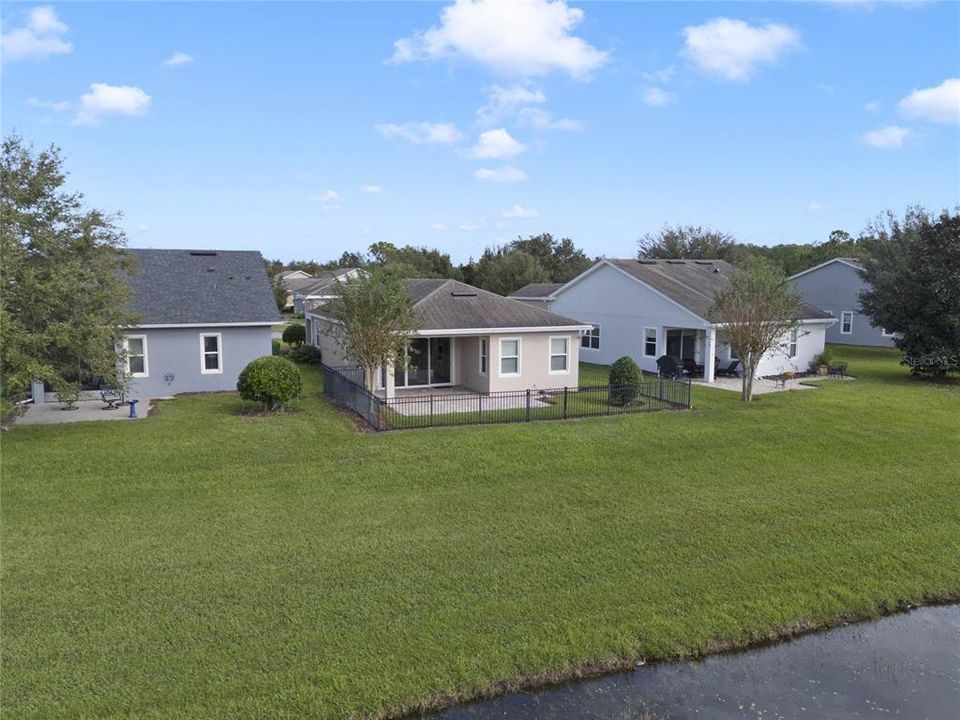 Aerial view of rear of home from above the pond