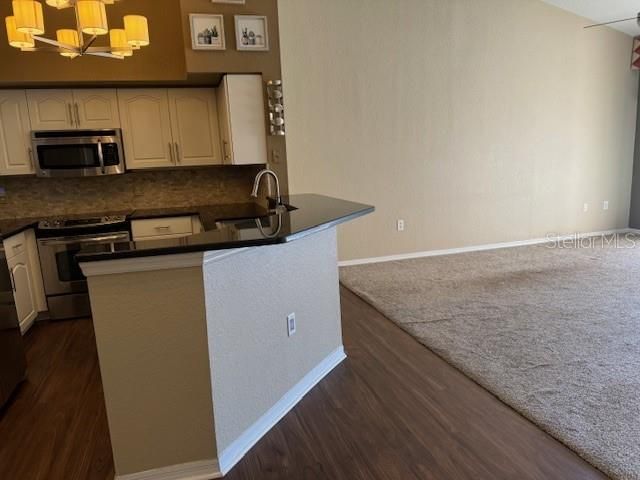 Kitchen with granite countertops, stainless appliances ,and under cabinet lighting.