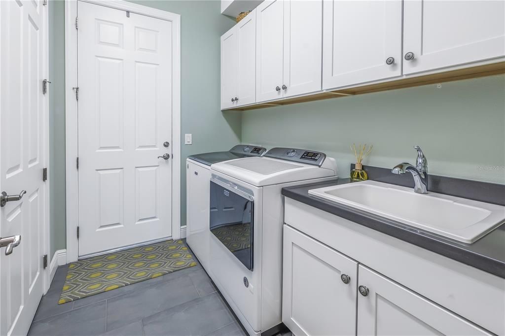 upgraded inside laundry with cabinets and sink, washer and dryer included