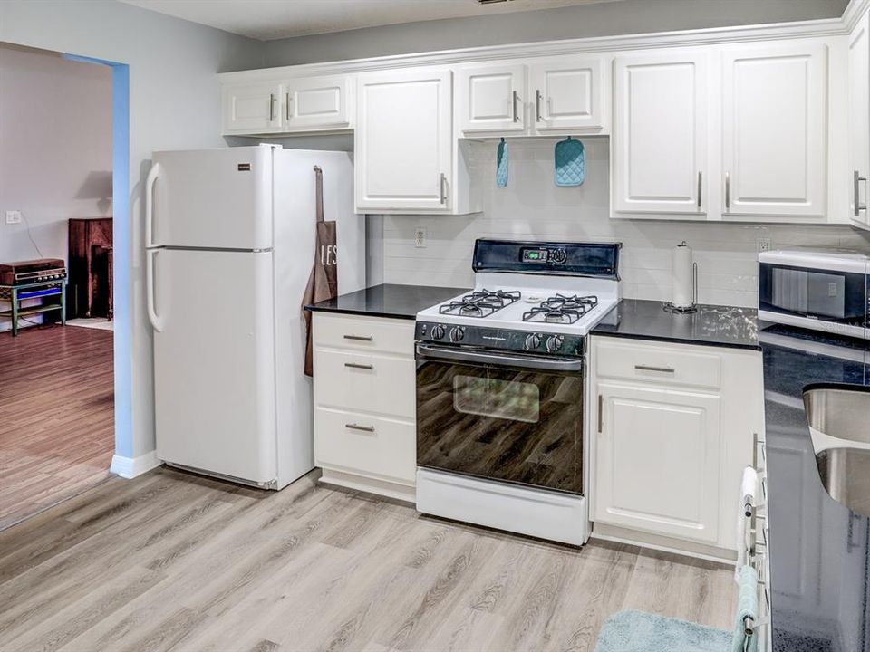 Kitchen with black granite counter tops. Gas stove.