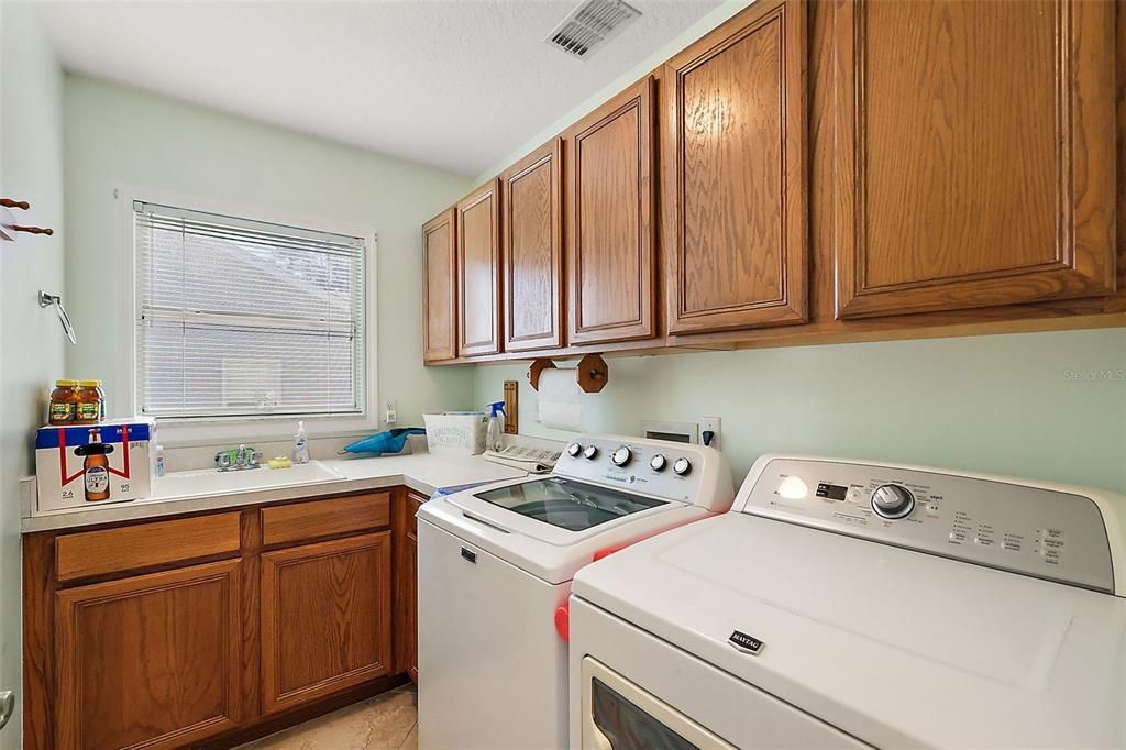 Laundry room with storage and a sink