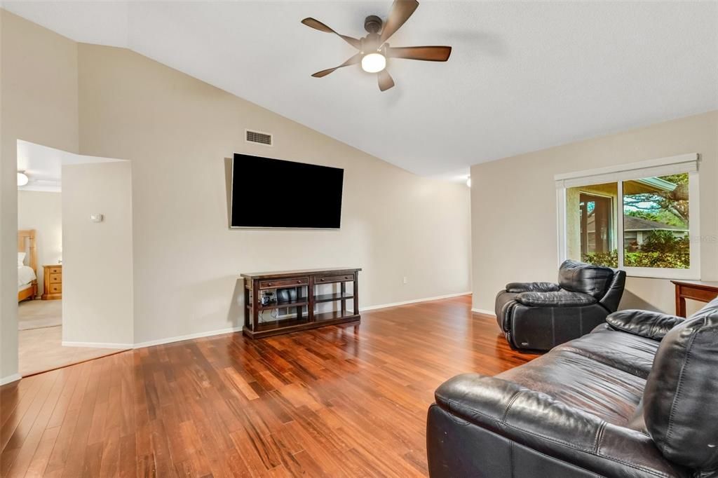 looking at living room and primary bedroom from the hallway of additional bedrooms