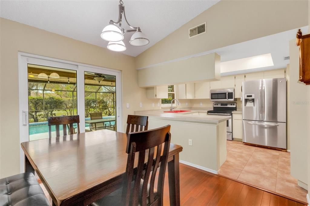 standing by desk looking at dining room and kitchen; view of pool area