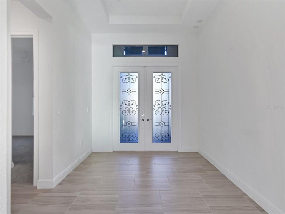 view of front door and entrance to 3rd bedroom