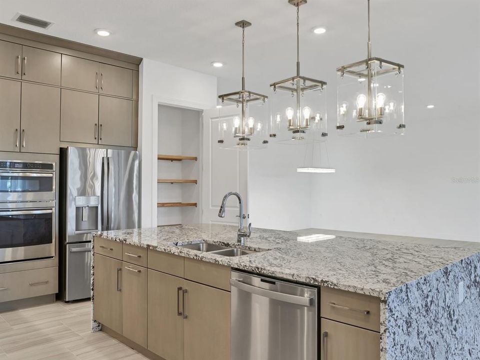 Same oversized pendants as model; pantry with wood shelves