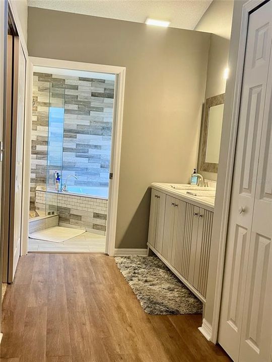 dressing area with his & her closets with storage