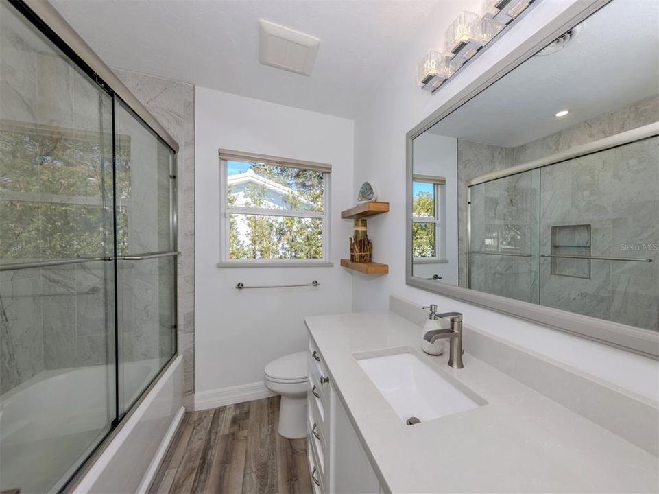 Second bathroom is clean, modern, and updated. Custom tile tub/shower enclosure and quartzite countertop. Lots of quality built-in storage for toiletries and towels.