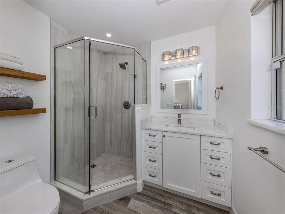 Spa like ensuite primary bathroom. Tiled shower and marble countertop