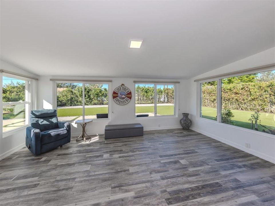 Large, enclosed, bright and airy Florida room with a west facing view, hurricane impact windows, and custom Levolor cellular window treatments for added privacy.